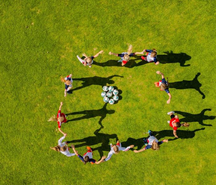 Dronefoto av fotballjenter på Trollbanen